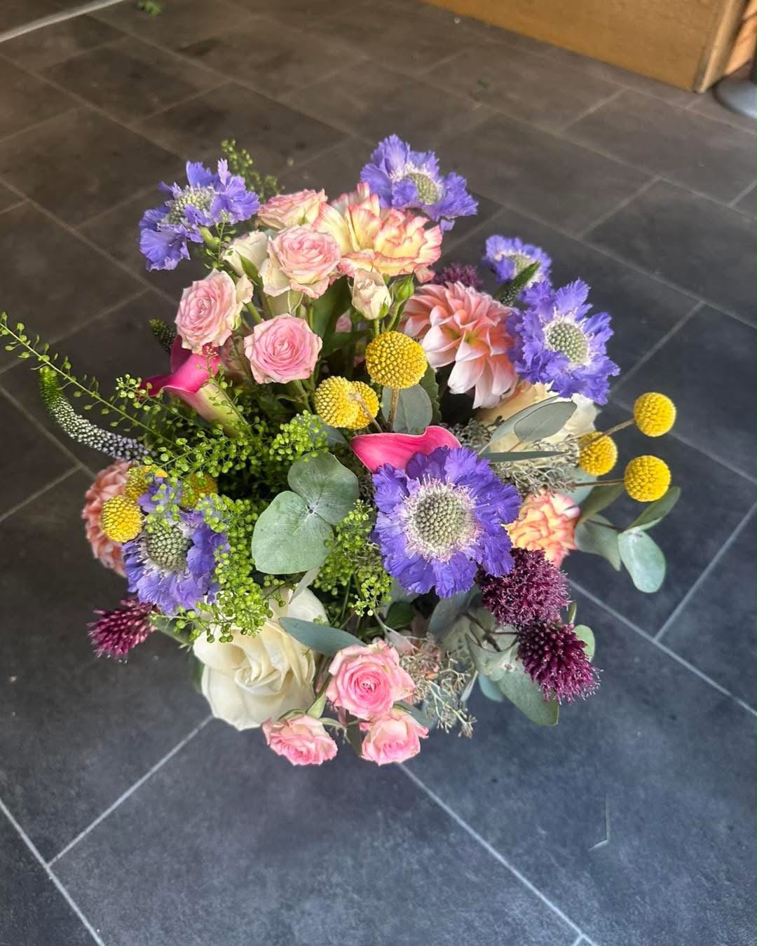 A colourful mixed bouquet with pink roses and purple flowers